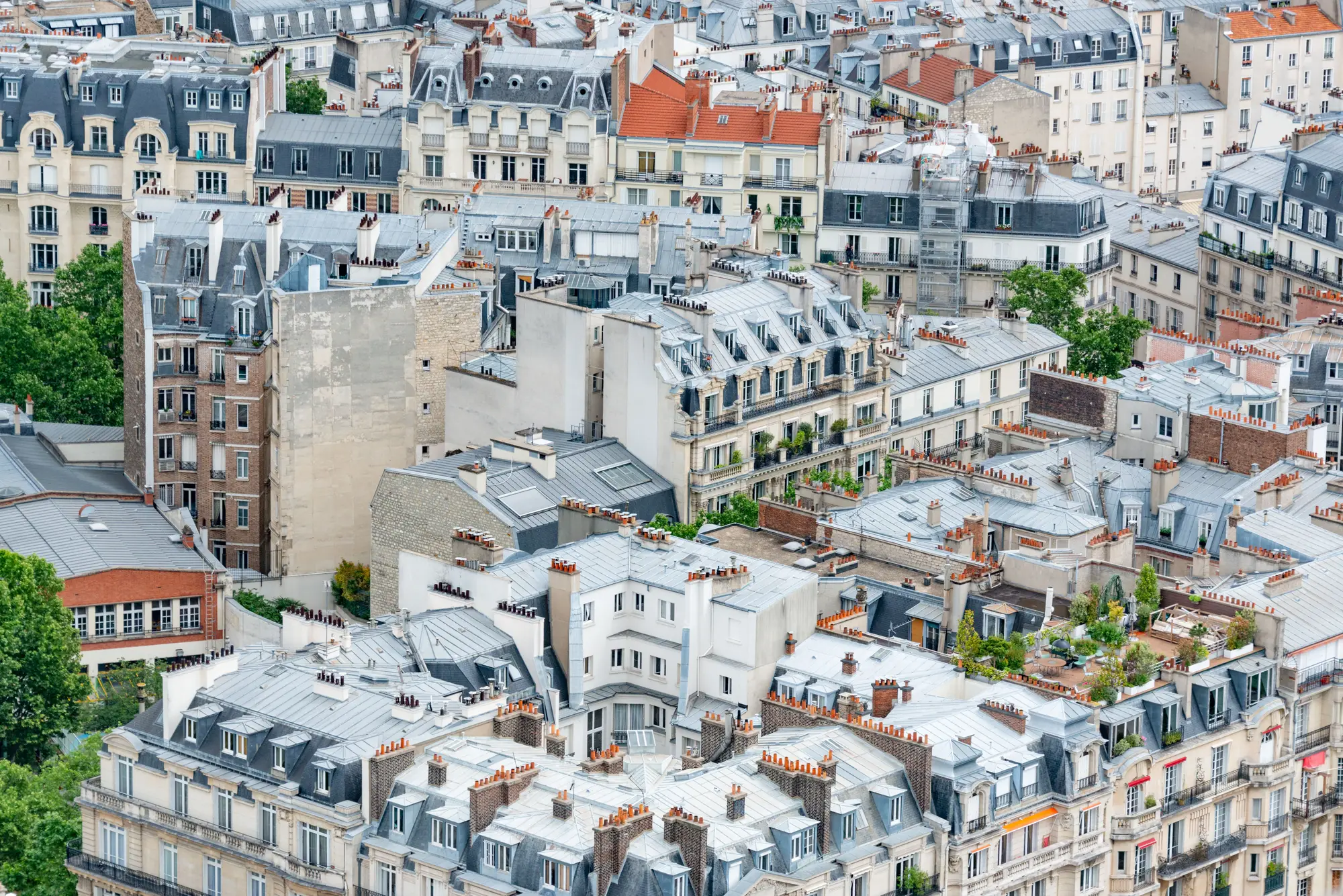 Paris rooftops and chimneys in summer light, seen from above.