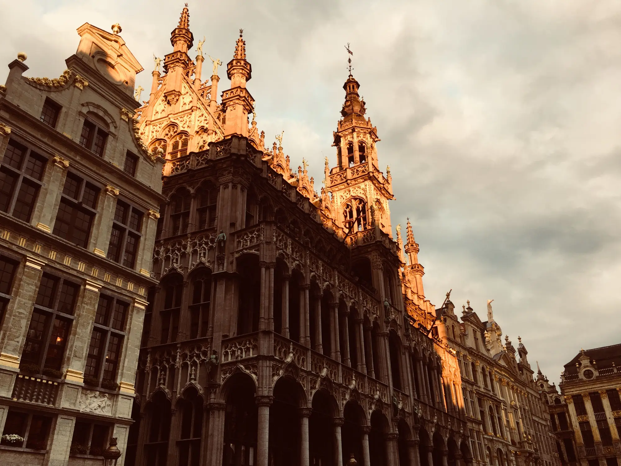 The gilded facades of the Grand Place in Brussels in golden evening light.